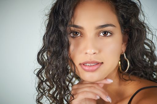 A closeup shot of a pretty woman in a curly hair with a beautiful pose