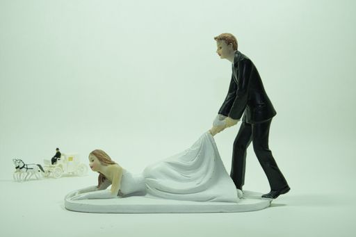An isolated miniature figure of groom grapping his pride and a cabriolet in sight with white background
