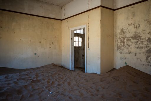 The inside of an abandoned building with damaged walls in an old desert town