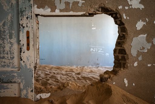 The inside of an abandoned building with damaged walls in an old desert town