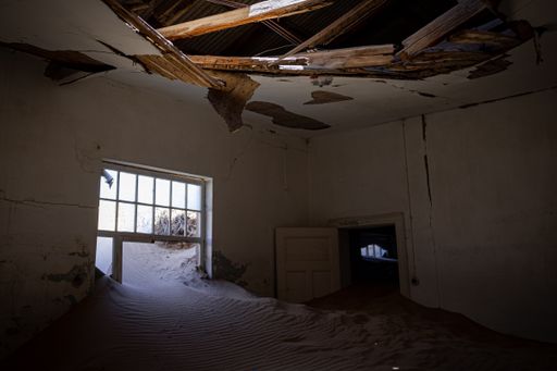 The inside of an abandoned building with damaged walls in an old desert town