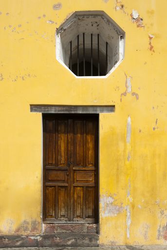 Entrance door and facade of houses in the colonial city of La Antigua Guatemala, details of Spanish colonial architecture, colorful and preserved.