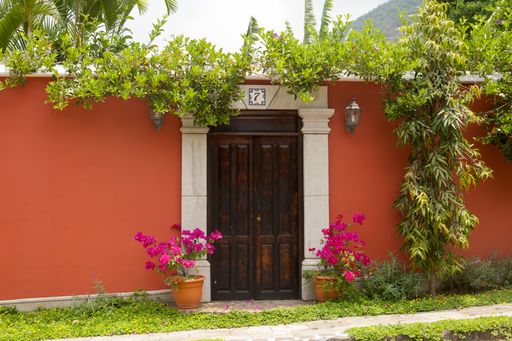 Entrance door and facade of houses in the colonial city of La Antigua Guatemala, details of Spanish colonial architecture, colorful and preserved.