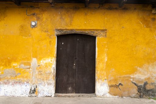 Entrance door and facade of houses in the colonial city of La Antigua Guatemala, details of Spanish colonial architecture, colorful and preserved.