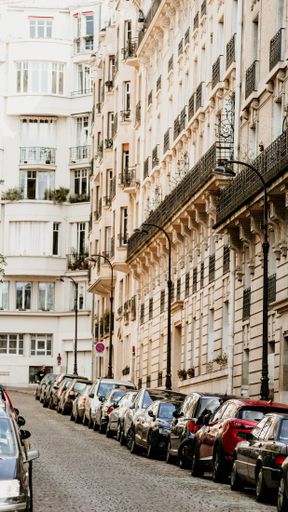 A vertical shot of a street with parking cars