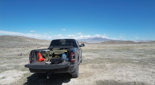 A pickup truck in a vast desert with mountains in the distance. Nevada, USA