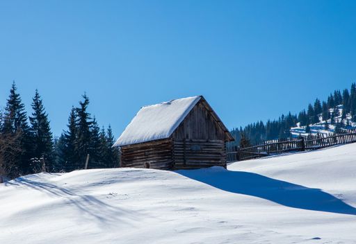 A landscape with an old wooden hut covered with snow in the mountain area