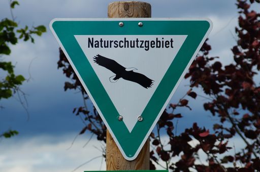 A sign tells you that you are in a nature reserve and that you should follow the rules. Do not leave paths, keep dogs on a leash.