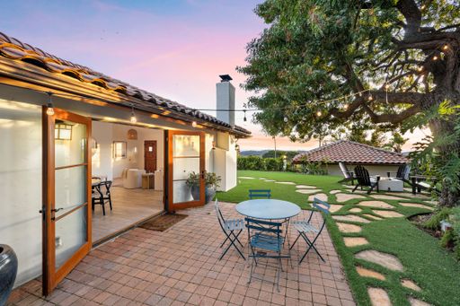 Outdoor patio with table and chairs in front of a house