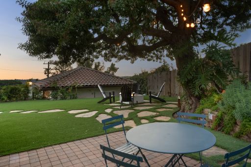 A stunning backyard with a green lawn and sitting area