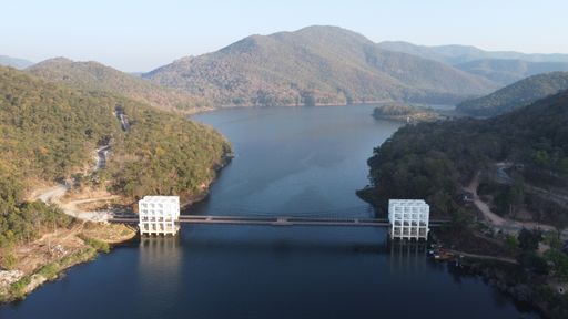 A breathtaking aerial view of a serene lake nestled amidst lush forests and majestic mountains