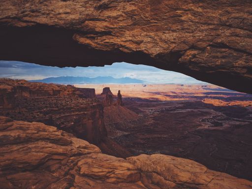 A beautiful shot from the middle of mesa arch with the mountain and the sky in the background at canyonlands national park