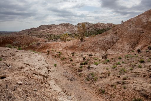 Clay-chalk hills of Kazakhstan with rare vegetation; Dense clouds in the sky.