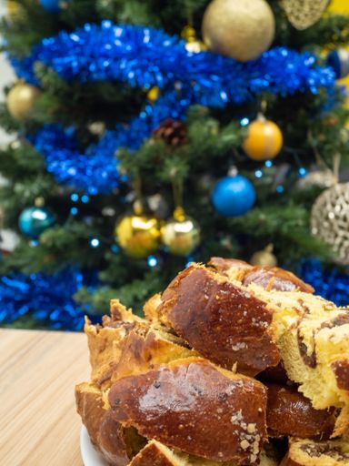 A freshly baked loaf of bread placed alongside a festive Christmas tree on a plate