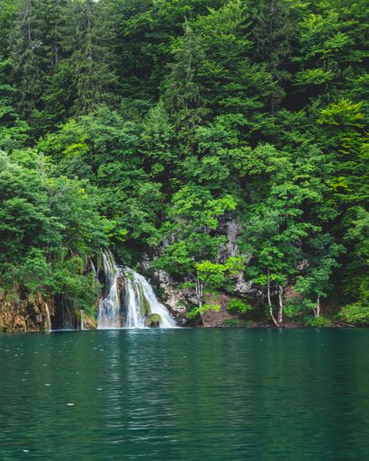 A beautiful waterfall surrounded by lush greenery in Plitvice Lakes National Park. Croatia