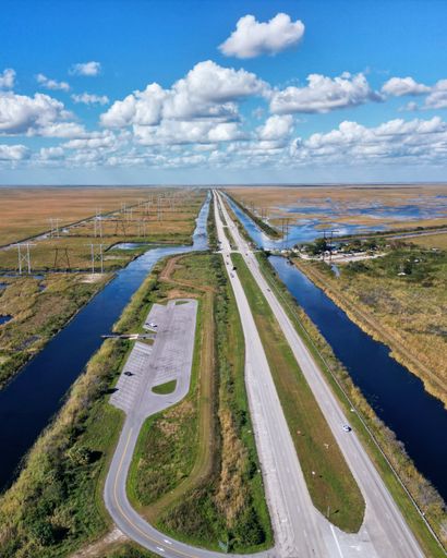A scenic highway winding through a beautiful marshland landscape