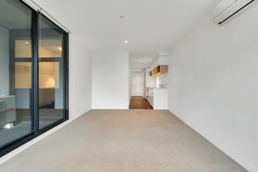 An empty kitchen room with laminate flooring and white walls