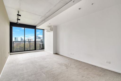 An empty room with sliding glass doors to a balcony