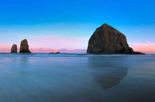 Sunset illuminates Cannon Beach's stunning rocks on a picturesque day