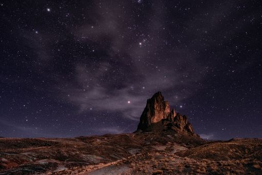 The scenic view of Agathla Peak against the backdrop of a starry sky. Monument Valley, Arizona