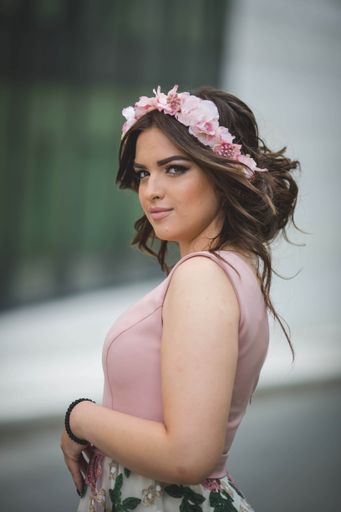 A pretty Caucasian woman with an evening dress and a floral bezel