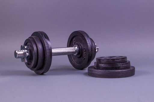 A closeup shot of a rubber dumbbell isolated on a purple background