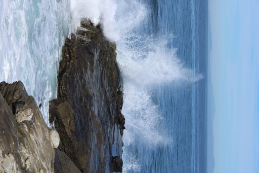 A majestic rock surrounded by crashing ocean waves