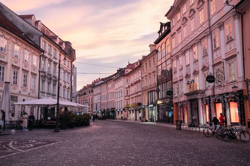 A charming nocturnal scene featuring vintage architecture and lively pedestrians on a bustling street