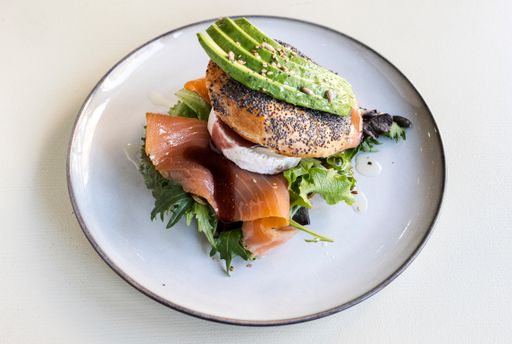 Delicious bagel filled with salted salmon, arugula, avocado and goat cheese