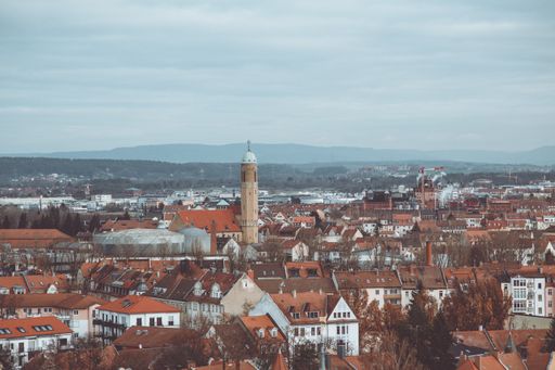 A beautiful shot of buildings with a tower in the distance under a blue cloudy sky