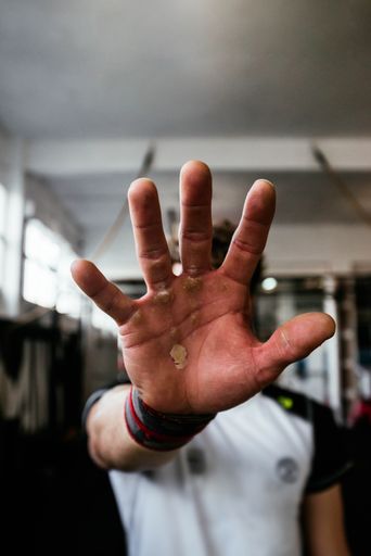 A vertical shot of an athlete male gesturing stop with his hand after intense training