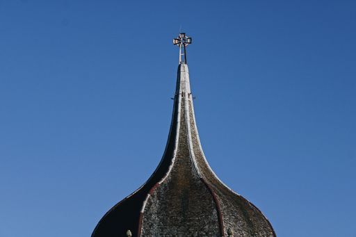 A beautiful view of decorative metal cross on a mosque against blue sky backgroun