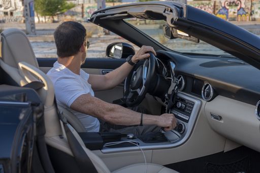adult enjoying a photo session with his car in a field