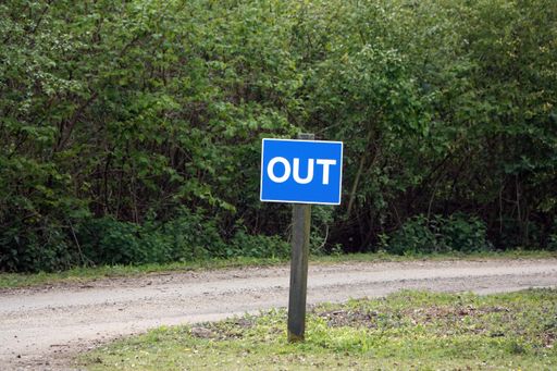 An out traffic sign in blue and white colors on the roadside