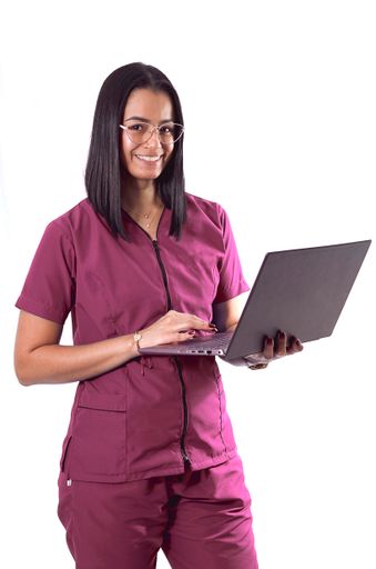 A vertical shot of a cheerful young Hispanic doctor/nurse wearing glasses holding a laptop