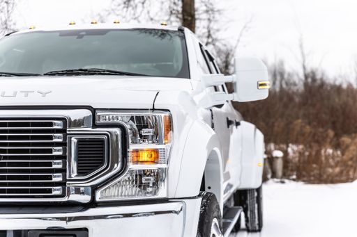 A parked truck covered in snow on a wintry street