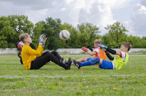 Young soccer goalkeepers train on a green lawn. Preparing athletes for future victories on the football field.