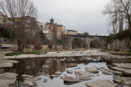 Stone bridge over water near buildings