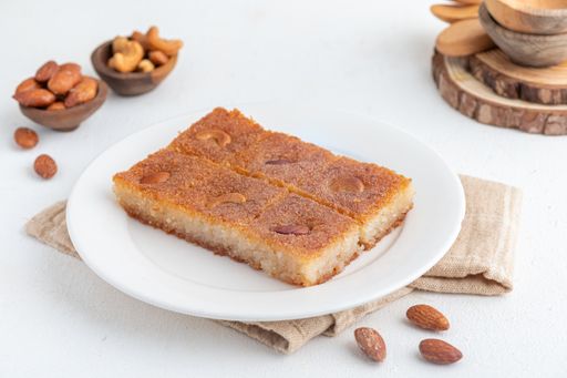 a plate topped with a piece of cake covered in nuts
