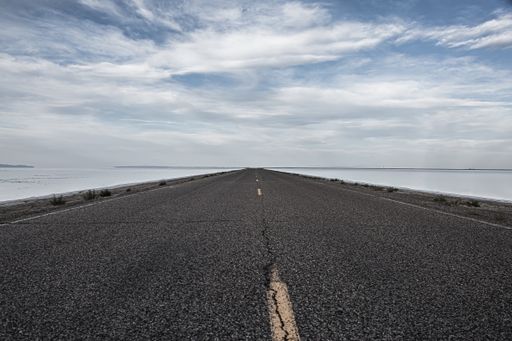 A beautiful view of empty asphalt road along a winter landscape under a cloudy sky
