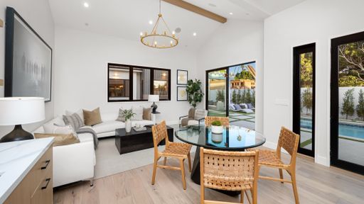 A spacious living room with hardwood floors and white walls