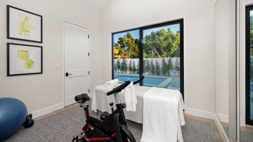 A room with gym equipment and an exercise ball on the floor