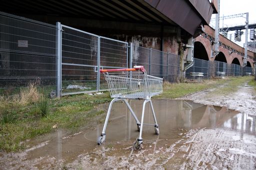 A shopping trolley left in a muddy puddle