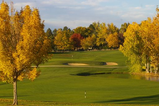 A Scenic golf course with trees, grass, and water in the foreground, Denver