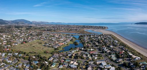 An aerial shot of Waikanae beach with the river mouth and ponds with Paraparaumu in the distance