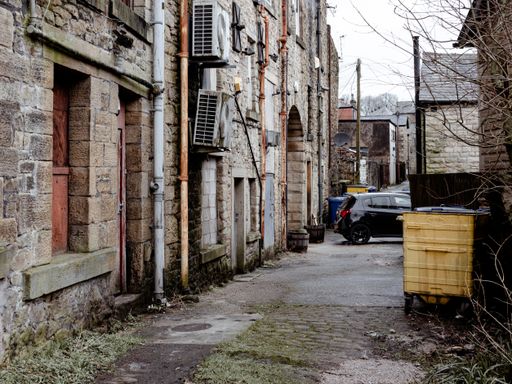 A dark and damp back alleyway of a northern town in England