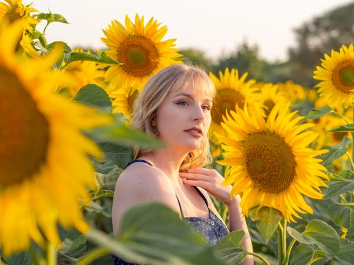 A beautiful young woman in the middle of a sunflower field