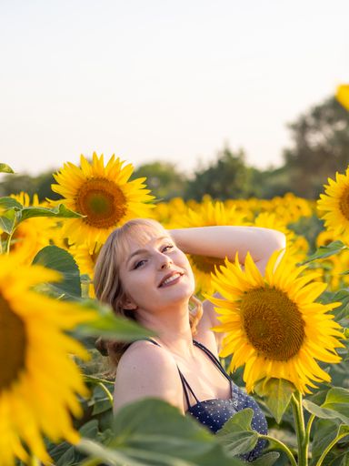 A portrait of a beautiful Caucasian woman enjoying freedom in the scenic sunflower field