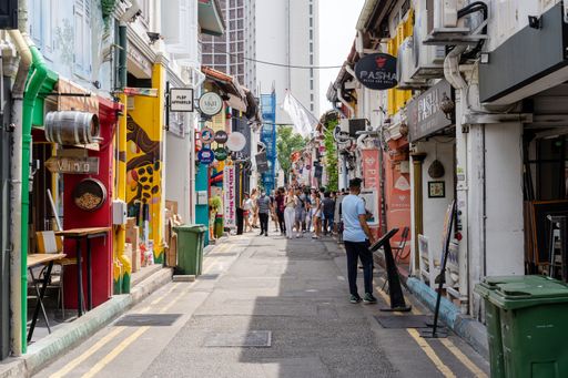 Crowd strolling through urban alley lined with shops
