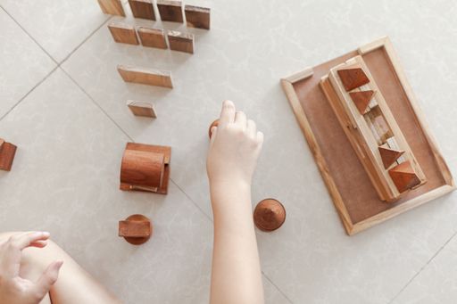 A child playing with wooden building blocks toys in a light minimalist interior